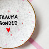 Vintage Wandteller "TRAUMA BONDED"– handbemalte Statement-Wanddeko aus Porzellan