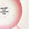 Vintage Wandteller "WIR LEBEN ALLE ZUM ERSTEN MAL" – handbemalte Statement-Wanddeko aus Porzellan